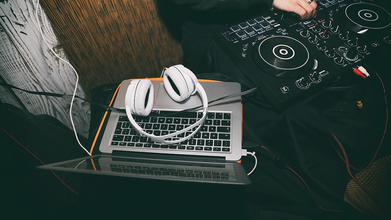 Headphones resting beside a laptop on a studio desk